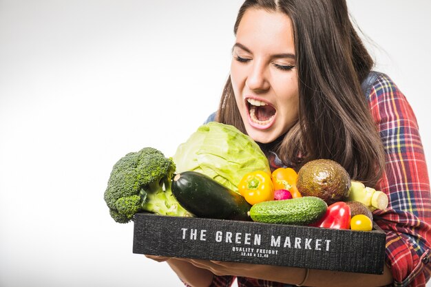 Woman pretending to bite vegetables