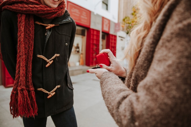 Woman proposing to man on city street