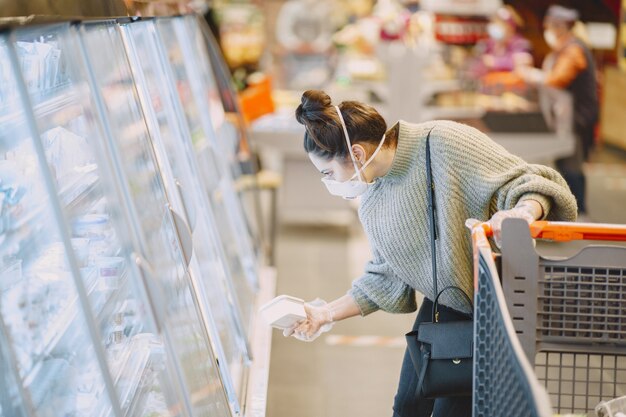 スーパーマーケットで防護マスクの女性