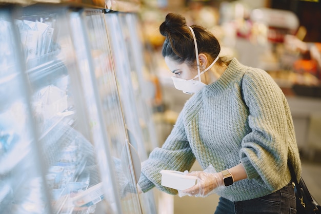 スーパーマーケットで防護マスクの女性