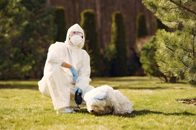 Free photo woman in a protective suit walking with a dog