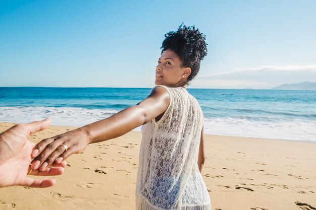 Woman pulling man at the beach