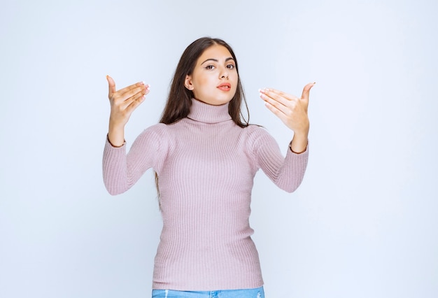 Foto gratuita donna in camicia viola che chiama e invita qualcuno.