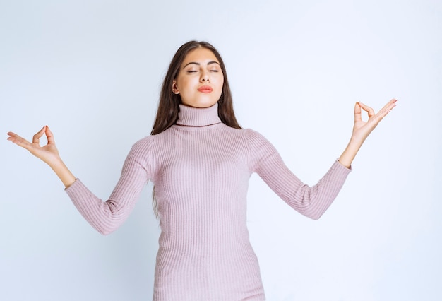 Donna in camicia viola che fa meditazione.