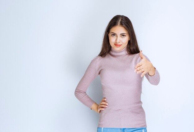 woman in purple shirt giving hand to greet someone.