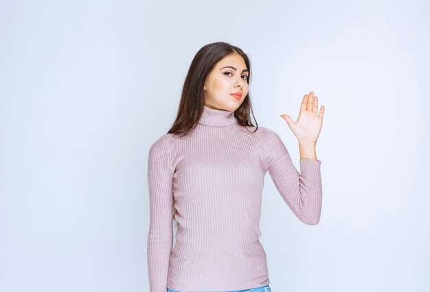 woman in purple shirt rejecting something with hand gests.