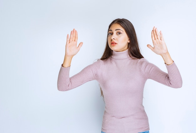 woman in purple shirt rejecting something with hand gests.