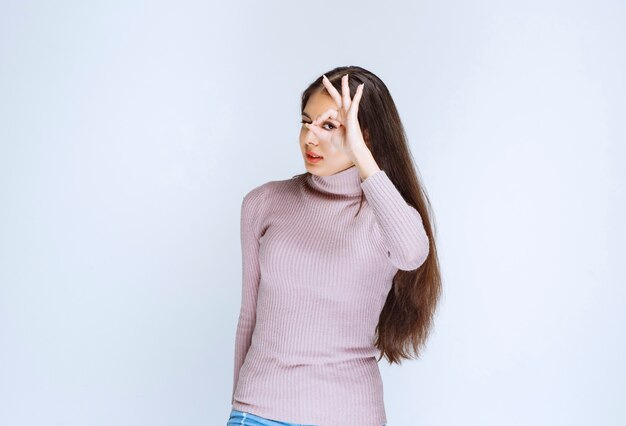 woman in purple shirt showing enjoyment hand sign.