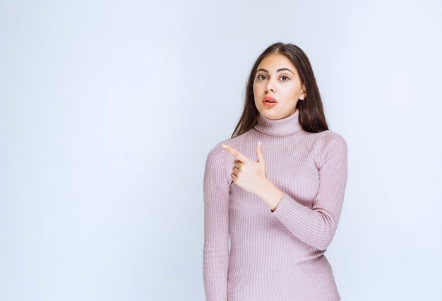 woman in purple shirt showing something on the left.