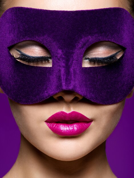 Woman in purple theatre mask on face with violet lips