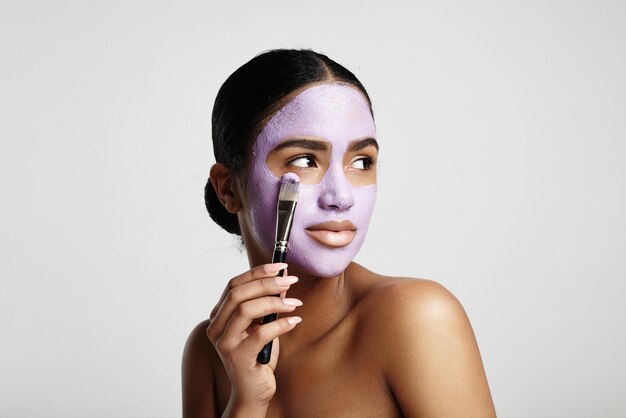 Woman put faacial mask with a brush