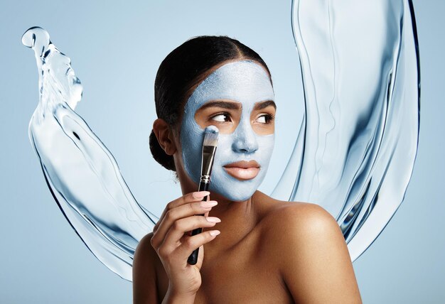 Woman put facial mask water splash on a background