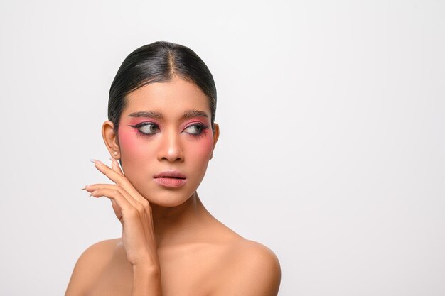 Woman put on pink makeup and put her hand on her face isolated on white