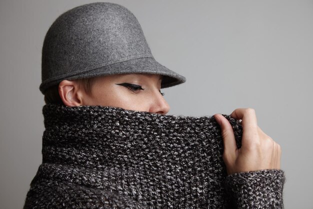 Woman put up collar of her wool grey cardigan