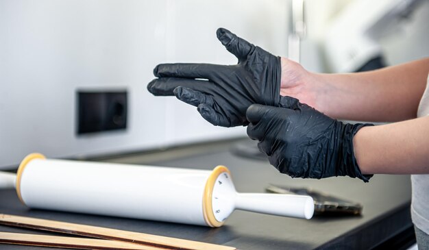 A woman puts on gloves in the kitchen kitchen work and hygiene