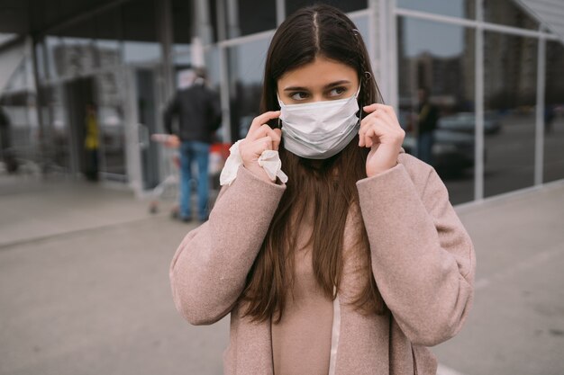 Woman puts on a protective medical mask.