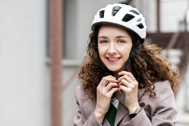 Woman putting on bike helmet