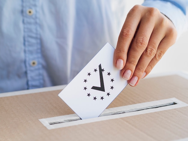 Foto gratuita donna che mette un voto europeo controllato in scatola