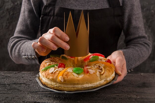 Woman putting a crown on dessert happy epiphany