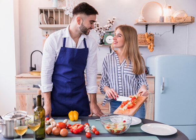 Woman putting cut vegetables on plate