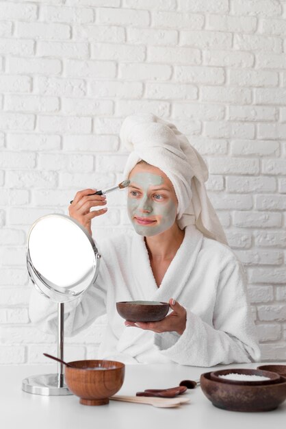 Woman putting on facial remedy