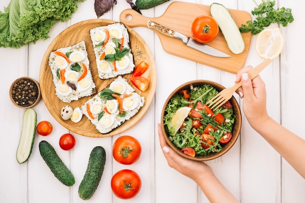 Foto gratuita donna che mette forcella in insalata