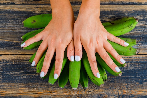Foto gratuita donna che mette le mani sulle banane verdi
