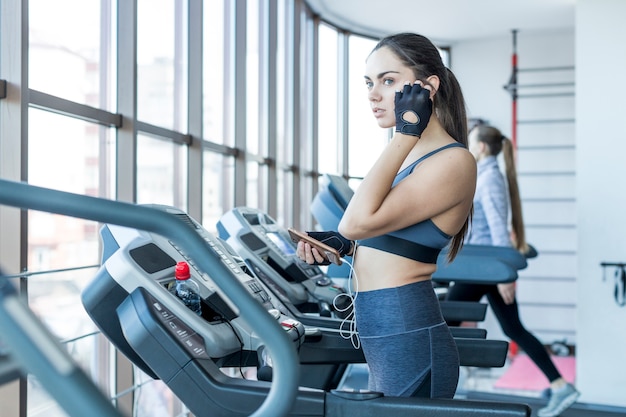 Free photo woman putting on headphone on race track