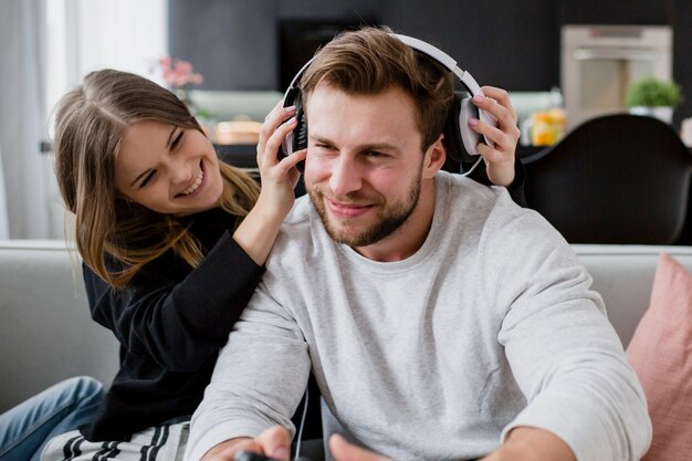 Woman putting headphones on man