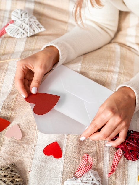 Woman putting hearts in envelope