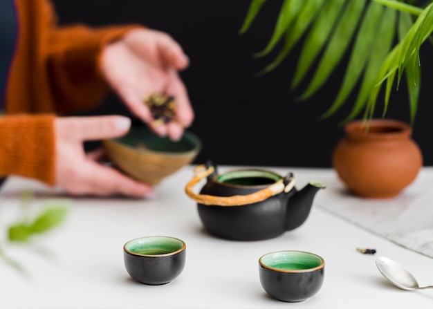 Woman putting herbs in tea