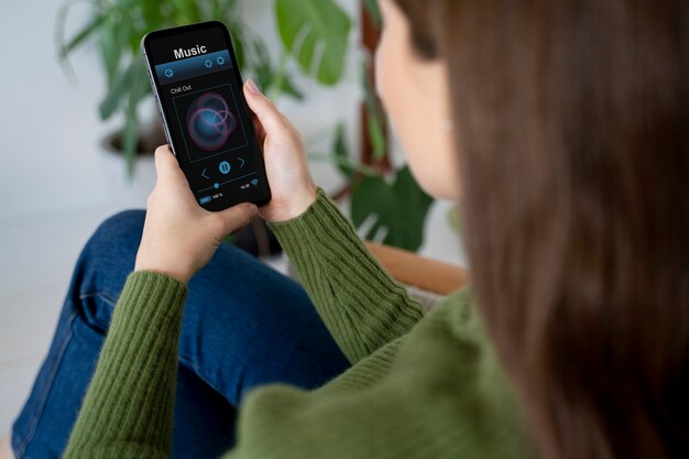 Woman putting on music using her smartphone while being at home