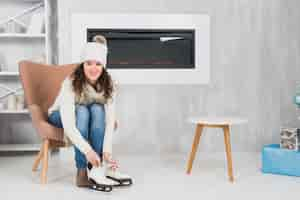 Free photo woman putting on skates in living room