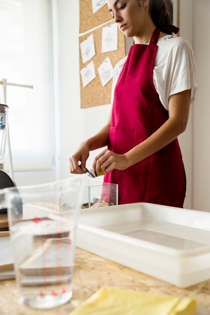 Женщина, помещая оторванные бумаги в стеклянный контейнер