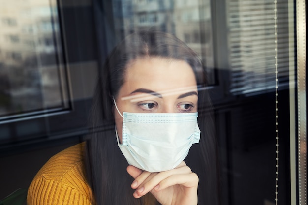Woman in quarantine wearing protective mask.
