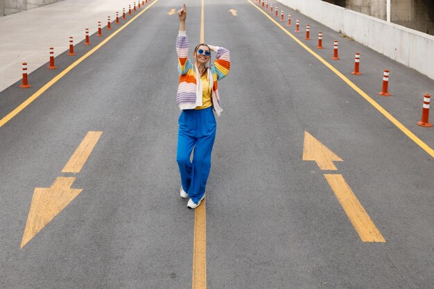 woman in rainbow wear dancing on the road