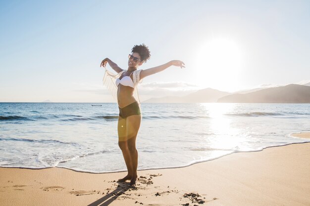 Woman raising arms at the beach