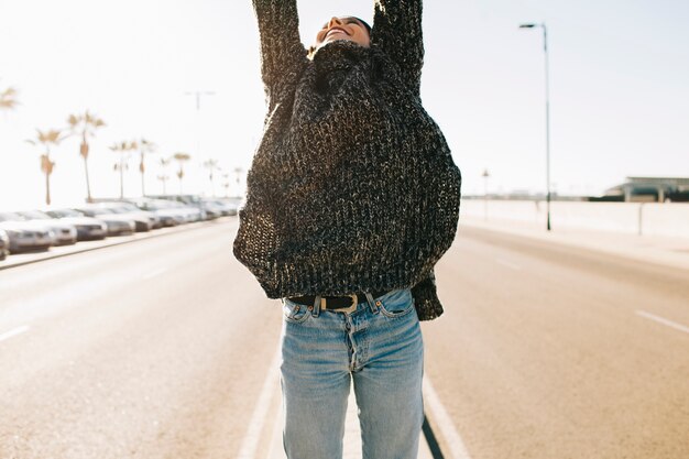 Woman raising arms in middle of street