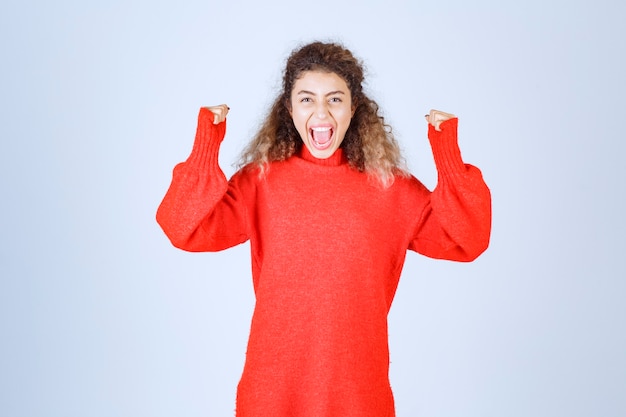 Free photo woman raising her fists and feeling successful.