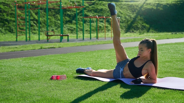 Woman raising leg up on grass