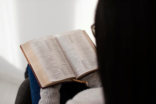 屋内で聖書を読んでいる女性