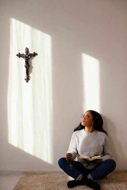 Женщина читает Библию в помещении