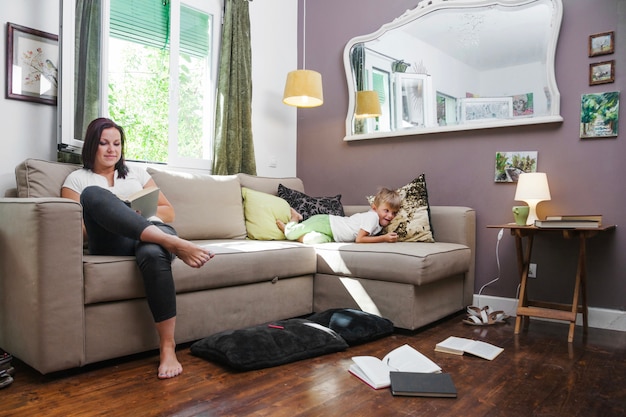 Woman reading book and boy lying