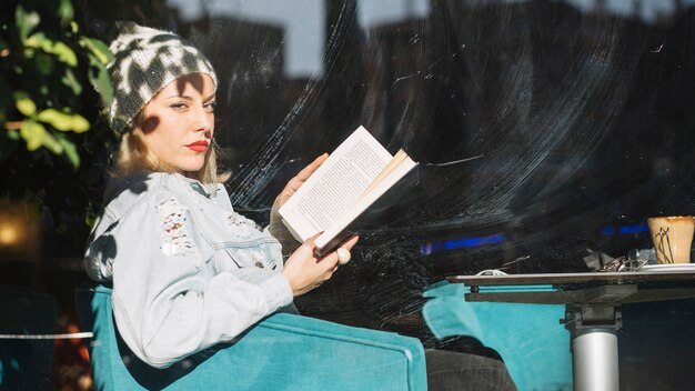 Woman reading book in cafe