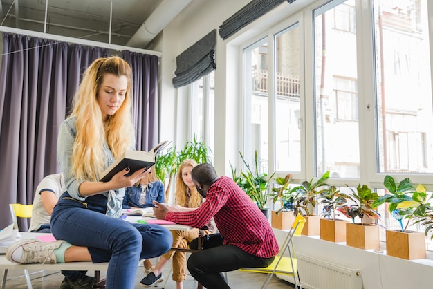 Woman reading book in classroom