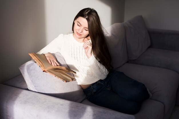 Woman reading book on couch