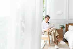 Free photo woman reading a book in her bedroom