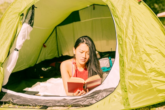 Бесплатное фото Женщина читает книгу в палатке