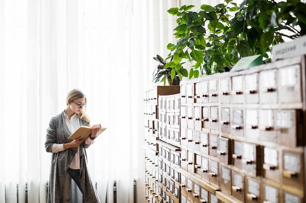 Woman reading book near window