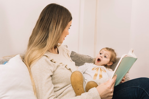 Woman reading book to shocked daughter